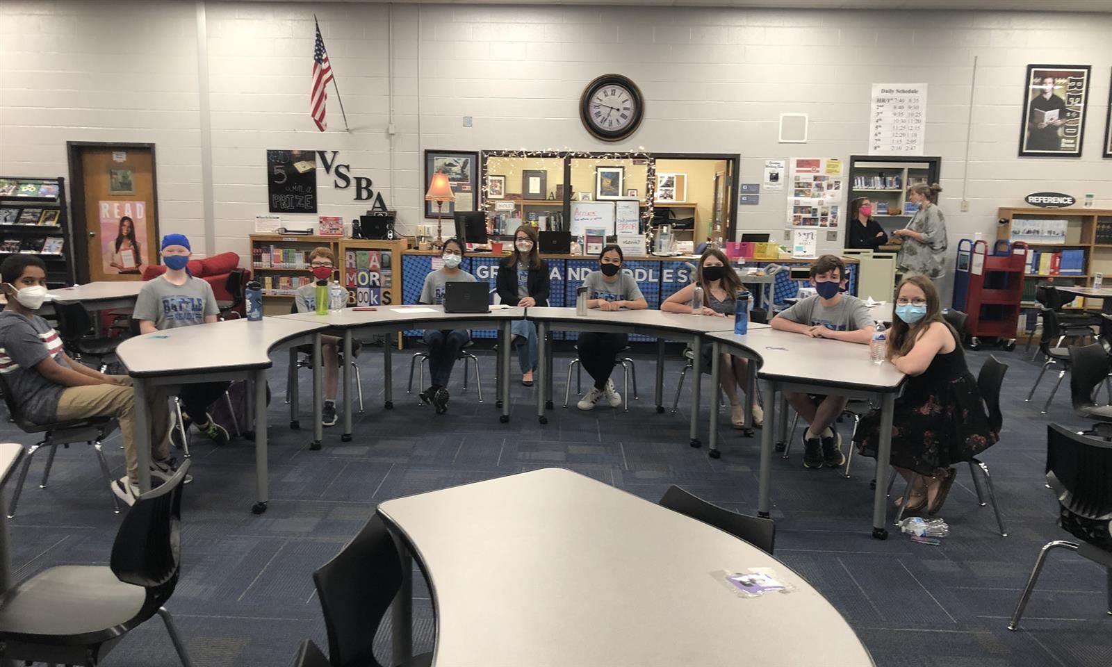 Students sit at a table in a library